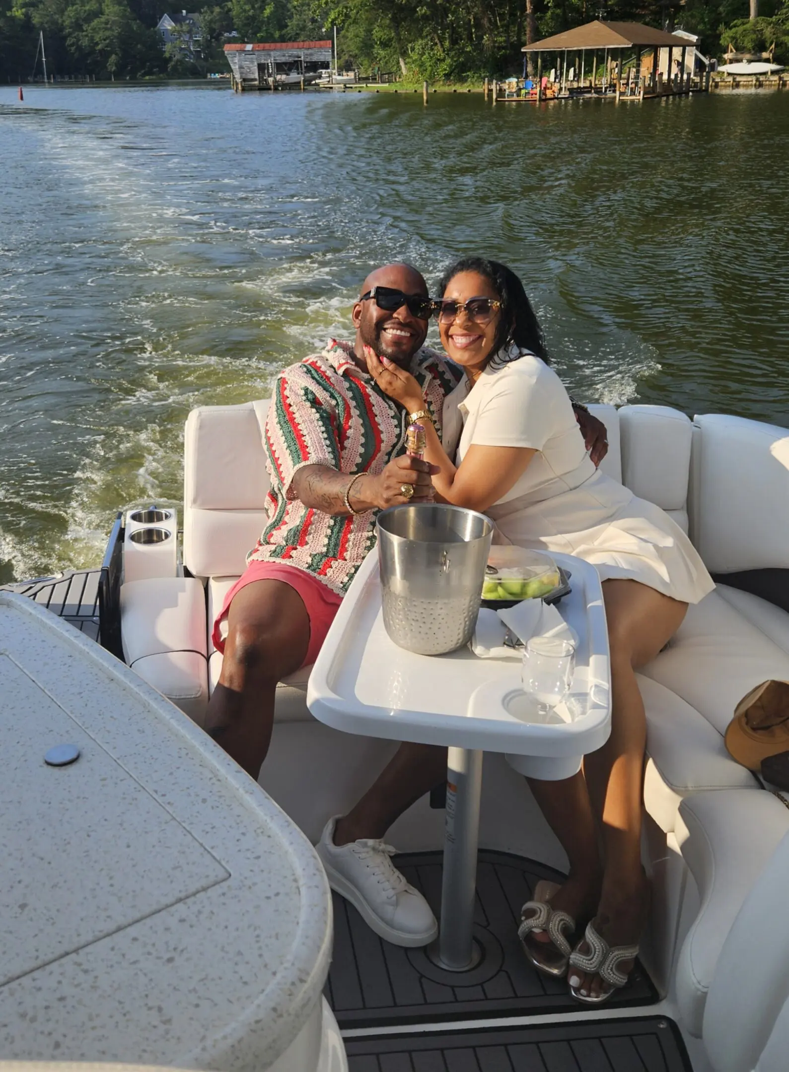 Couple enjoying a sunny boat ride together with drinks on the table.