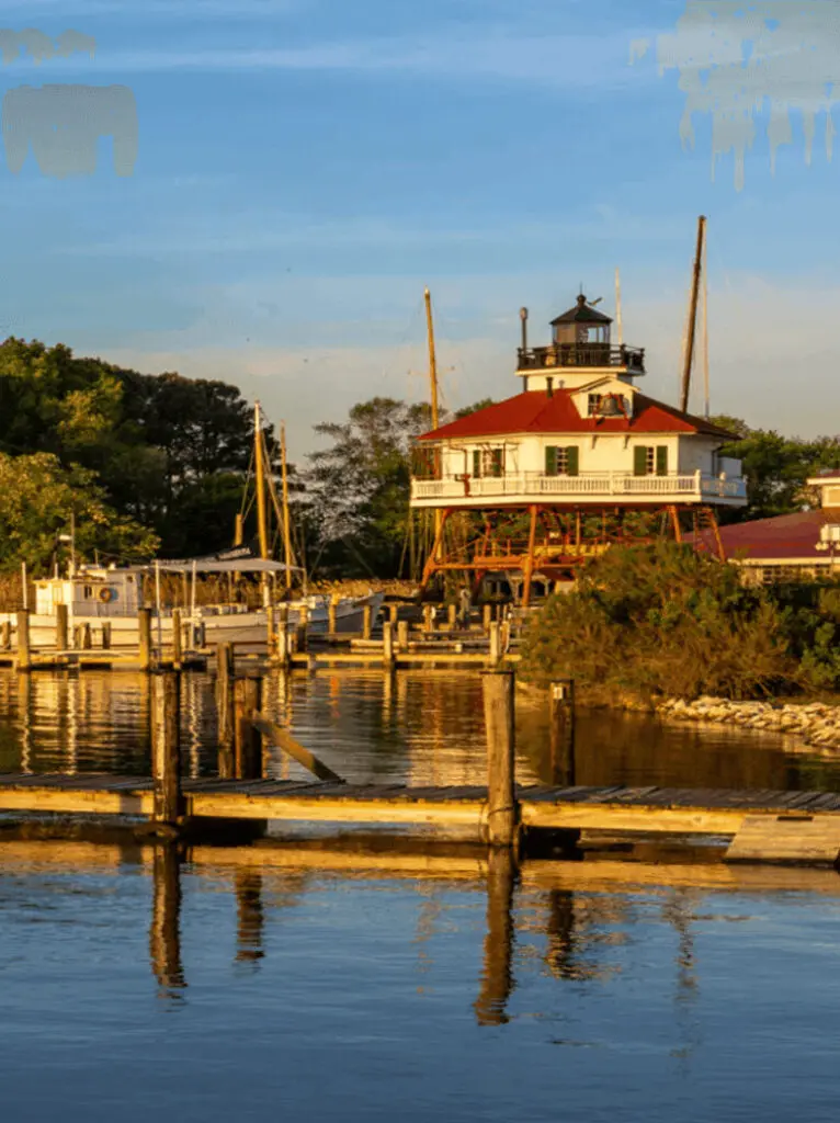 A lighthouse by the water during golden hour.