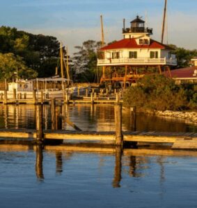 A lighthouse by the water during golden hour.